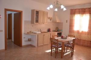 a kitchen with a table and a table and chairs at CASA ANGELO in San Vito lo Capo