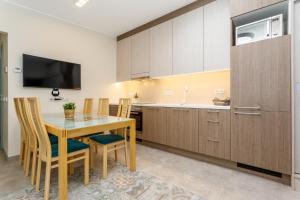 kuchnia ze stołem, krzesłami i telewizorem w obiekcie Gardenview Selection by Kerese Apartments w Parnawie