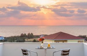 a table with a vase of flowers on a balcony at Apartments Hotel & Studios, Xifoupolis in Monemvasia