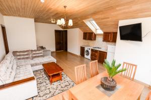 a living room with a couch and a table at Svečių Apartamentai Vanagupėje in Palanga