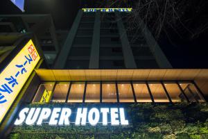 Super Hotel Tokyo Kinshicho Ekimae في طوكيو: علامة على فندق ممتاز أمام مبنى