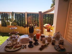 einen Tisch mit Teller mit Lebensmitteln auf einem Tisch mit einem Zaun in der Unterkunft La Perla Scala dei Turchi in Realmonte