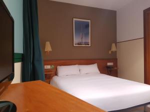 1 dormitorio con 1 cama y escritorio con TV en El Jardi, en Barcelona