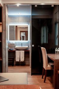 ein Badezimmer mit einem Waschbecken und einer Theke mit einem Tisch in der Unterkunft La Trobada Hotel Boutique in Ripoll + 37 Fotos