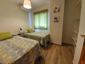 Habitación con 2 camas y ventana en Gálvez Flat, at principal railway station in Málaga, en Málaga