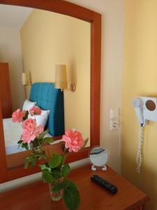 a room with a mirror and a table with flowers at Amalia in Paleo Tsifliki