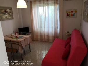 ein Wohnzimmer mit einem roten Sofa und einem Tisch in der Unterkunft Apartmans Luce e Stella in Malinska