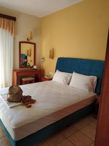 a bedroom with a large bed with a blue headboard at Amalia in Paleo Tsifliki