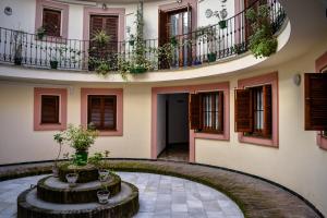 une cour d'un bâtiment avec une fontaine et des plantes dans l'établissement ESTUDIO 10 Junto a La Campana Alameda Setas, à Séville