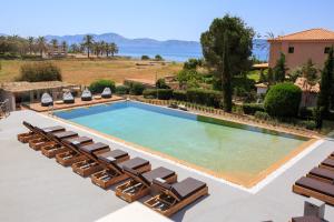 an overhead view of a swimming pool with lounge chairs at 180 South Seaside Hotel in Thermisia