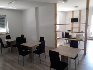シュプレムベルクにあるCity Pension Sprembergのテーブル2台、椅子1脚、棚1台が備わるお部屋