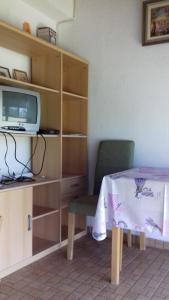 Zimmer mit einem Tisch, einem TV und einem Stuhl in der Unterkunft Apartment Bella Vista Park view in Poreč