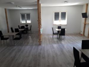 an empty room with tables and chairs and windows at City Pension Spremberg in Spremberg