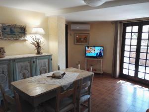 バージャ・サルディニアにあるAppartamento Villa Ederaのリビングルーム(テーブル、テレビ付)