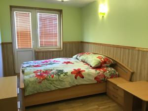 a bedroom with a bed and a desk and two windows at Jaani 2 Apartment in Pärnu