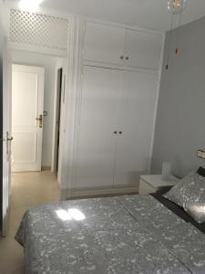 a bedroom with a bed and a white wall at Apartamento Trinidad mit Netflix in Fuengirola