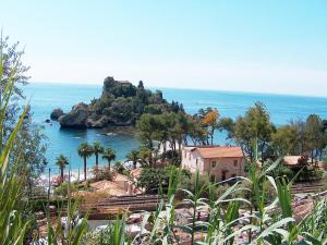 a view of a beach with a house and the ocean at Etna Snow&Sea in Piedimonte Etneo