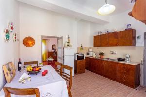 a kitchen with a table with a bowl of fruit on it at Casa Maritina Traditional Family House in Gennadi