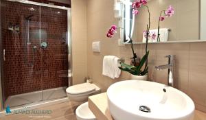 a bathroom with a sink and a toilet and a shower at Alma di Alghero Hotel in Alghero