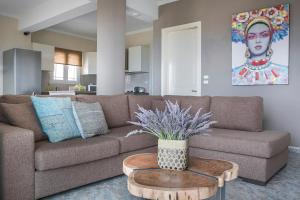 a living room with a brown couch and a table at Villa Alessandra in Markópoulon