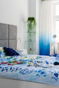 una camera da letto con un letto con un piumone blu di Hello Apartments Chlebnicka a Danzica