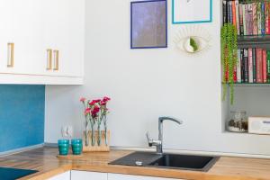 una cucina con lavandino e bancone con fiori di Hello Apartments Chlebnicka a Danzica Altre 32 foto