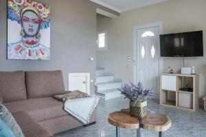 a living room with a couch and a painting on the wall at Villa Alessandra in Markópoulon