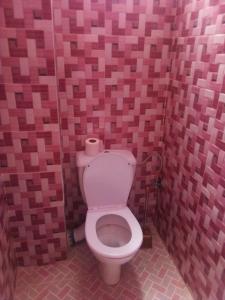 a bathroom with a toilet in a pink tiled wall at Hotel la belle vue 2100m in Taroudant