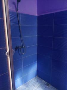 y baño con ducha de azulejos azules. en Hotel la belle vue 2100m en Taroudant