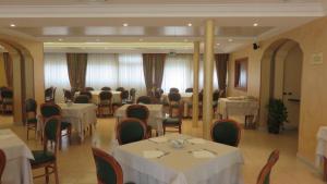a dining room with tables and chairs with white table cloth at Hotel Oasi Dei Discepoli in Orvieto