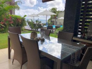 a dining table and chairs with a view of the ocean at Beach Apartment - Trou aux Biches - Ground Floor in Mont Choisy