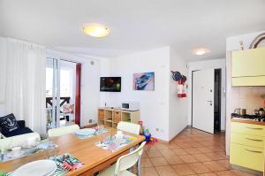 eine Küche und ein Esszimmer mit Tisch und Stühlen in der Unterkunft Residence Corallo in Caorle