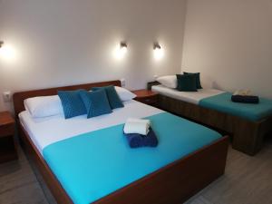 two beds in a room with blue and green at APARTMANI NOVA in Živogošće