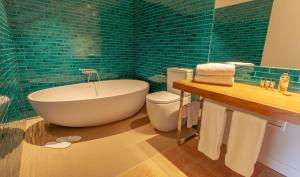 パラフルジェイにあるCan Liretの緑のタイルのバスルーム(バスタブ、トイレ付)