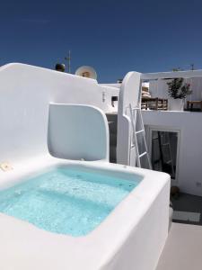 a white chair with a tub in a room at Roofs Of Chora in Mikonos
