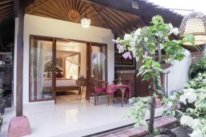 a guest house with a dining room and a bedroom at Budi House Bungalows in Ubud