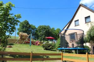 a yard with a playground and a house at Ferienwohnung Troge in Kurort Gohrisch