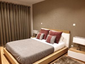 ラゴスにあるTourismerのベッドルーム1室(大型ベッド1台、赤い枕付)