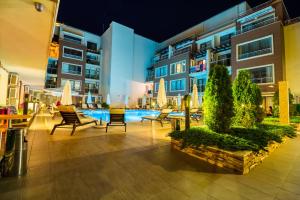 a courtyard with chairs and a pool in a building at Aпартаменти Хоризонт in Sozopol