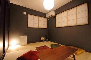 a living room with a table and some pillows at Fuji Time traveler 新館 in Fujikawaguchiko