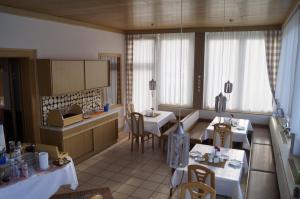 a kitchen with two tables and a kitchenasteryasteryasteryasteryasteryasteryasteryastery at Pension DOBERNIG - CONTACTLESS CHECK IN/STAY in Klagenfurt