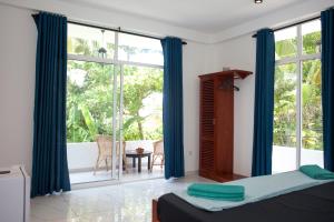 a bedroom with a bed and a large window at Alvas house in Hikkaduwa