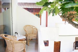 a room with a table and chairs on a balcony at Alvas house in Hikkaduwa