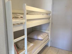 ein Etagenbett mit einem Kissen auf dem unteren Regal in der Unterkunft Studio cabine Toi et Moi à 30 m de la plage de Valras centre in Valras-Plage