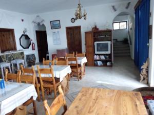 a dining room with tables and chairs and a tv at Kriti Studios in Agia Galini