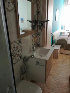 a bathroom with a sink and a toilet and a mirror at B&B Stella del Mare in Lampedusa