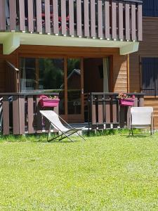 two chairs and a table in front of a house at Le Marquis in Morzine