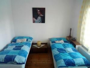 a bedroom with two beds and a painting on the wall at U Žaludů in Ledenice