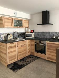a kitchen with wooden cabinets and a sink and a microwave at Baiona in Bayonne