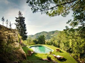 a swimming pool in the middle of a yard with mountains at Agriturismo Biologico Castello Della Pieve in Mercatello sul Metauro